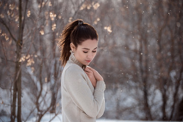 Sad young woman in the sun in early spring
