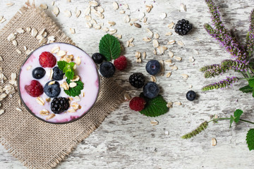 Fototapeta na wymiar yogurt with fresh ripe berries, oats and mint. healthy breakfast