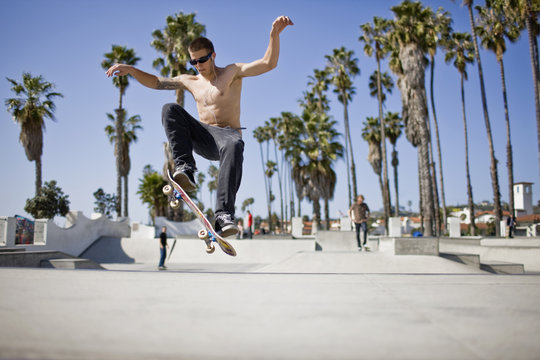 Teenage boy doing jump on a skateboard
