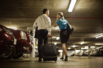 Two business partners walking through public parking place.