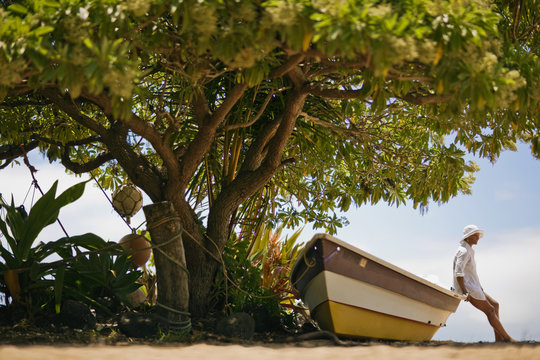 Side view of woman sitting on dinghy at beach