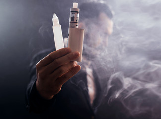 Man smokes electronic cigarette. Smoking e-cigarette. Close up shot