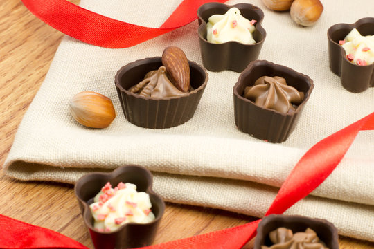 chocolate candy with nuts on burlap with a red ribbon