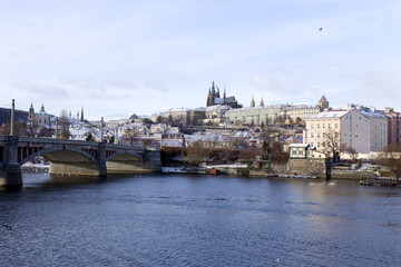 Fototapeta na wymiar Snowy freeze Prague Lesser Town with gothic Castle above River Vltava, Czech republic