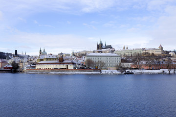 Fototapeta na wymiar Snowy freeze Prague Lesser Town with gothic Castle above River Vltava, Czech republic
