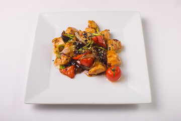 Teriyaki chicken with cherry tomatoes on a white background