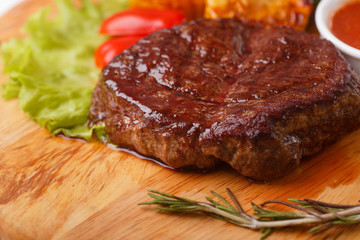 ribeye steak grilled with rosemary on a wooden