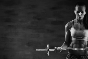 Young woman training with barbell. Black and white photo