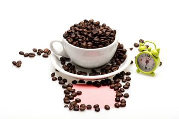 coffee cup, beans, alarm clock and paper isolated on white