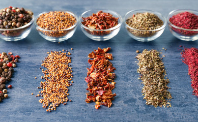 Various spices in glass bowls on grey table