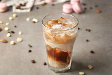 Glass of cold coffee with milk on table