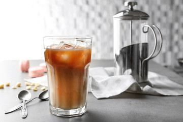 Glass of cold coffee with spoons on table