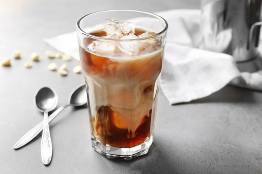 Glass of cold coffee with spoons on table