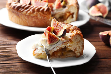 Piece of fresh cake with figs on saucer closeup