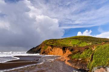 Obraz premium Stormy weather by a cliff at beach