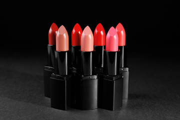 Many lipsticks on dark background