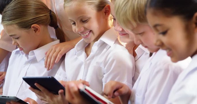 Teacher teaching kids on digital tablet in classroom at school 4k