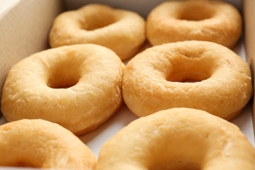 Delicious donuts in a cardboard box, closeup