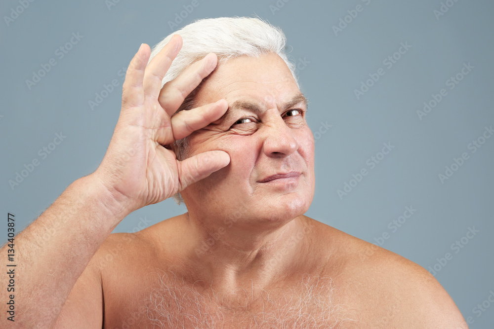 Wall mural Portrait  of senior man on grey background