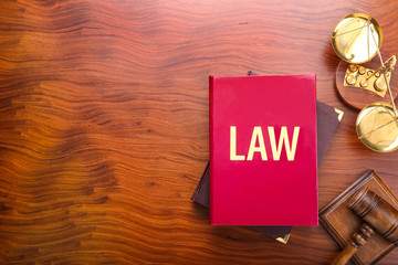 Judge gavel with scales and books on wooden background