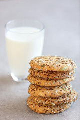 Delicious cereal cookies with glass of milk on color background