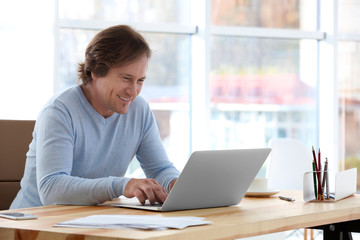 Mature man working with laptop in office