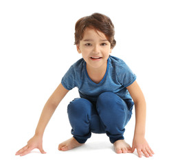 Cute emotional little boy sitting on white background