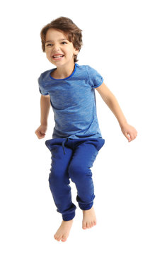 Cute emotional little boy jumping on white background