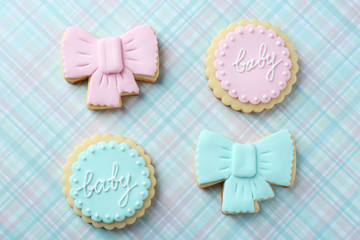Baby cookies decorated with glaze on color background