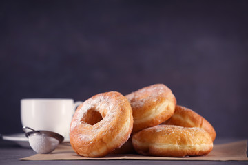 Tasty donuts with cup of coffee on table