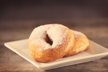 Plate with tasty donuts on table