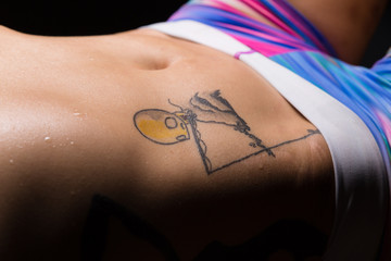 Closeup of stomach and hips of an athletic young asian woman with tattoos