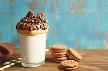 Milkshake, donut and other sweets in glass on blue background
