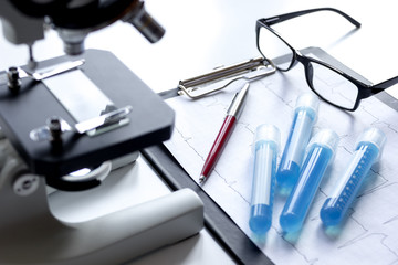 doctors desk with microscope and test tubes