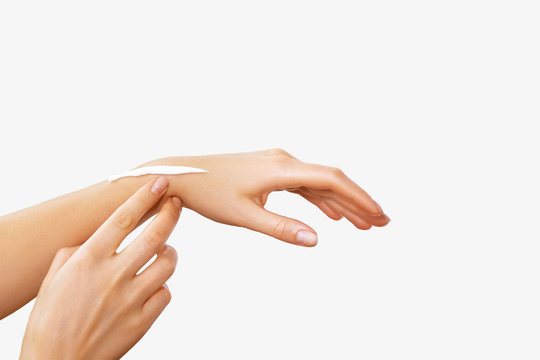 Female hands with a moisturiser on light background. Close-up of Woman Applying Cream on Hand. Hands Skin Care.