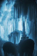Huge ice icicles. Large blocks of ice frozen waterfall or water. Blue ice background. Frozen stream...