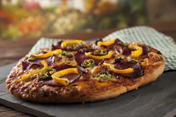 Tasty pizza, tomatoes and others ingredients on a wooden backgro