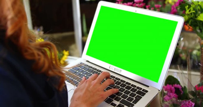 Female florist using laptop in flower shop