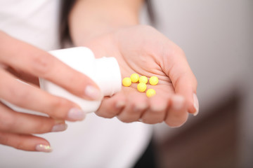 Woman holding pill in hand.