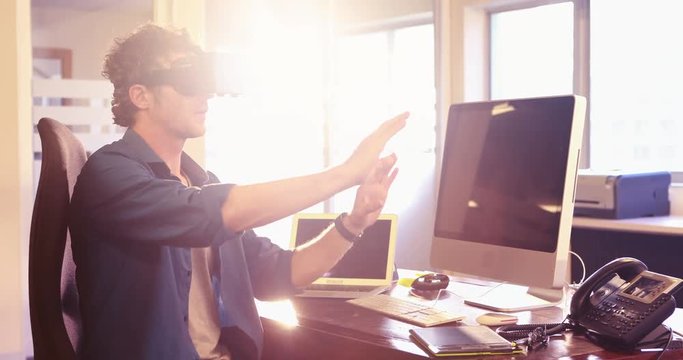 Male graphic designer using reality headset in office