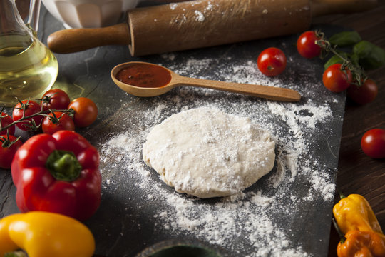 Preparing pizza with dough and tomato sauce