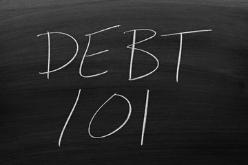 The words "Debt 101" on a blackboard in chalk