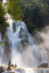 LUANG PRABANG, LAOS - OCTOBER 10: Unidentified tourists at the main waterfall at Kuang Si Waterfall near Luang Prabang, Laos on October 10, 2014.