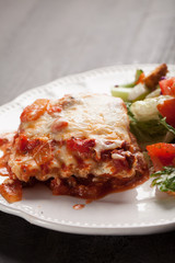Homemade Italian four cheese lasagna with an Italian salad macro shot