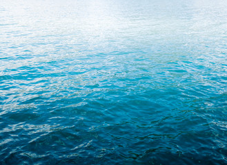 Blue ripple water wave on sand in sea ocean with copy space.