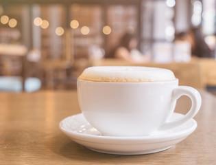Cup of Cappuccino Coffee with foam froth cover on top. Cafe shop