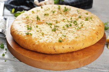 Plate with tasty garlic bread on wooden table