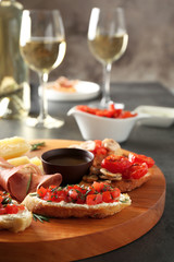 Tasty bruschetta served with white wine on table