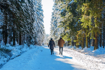 couple walking in a snowy forest