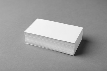 Stack of blank business cards on grey background